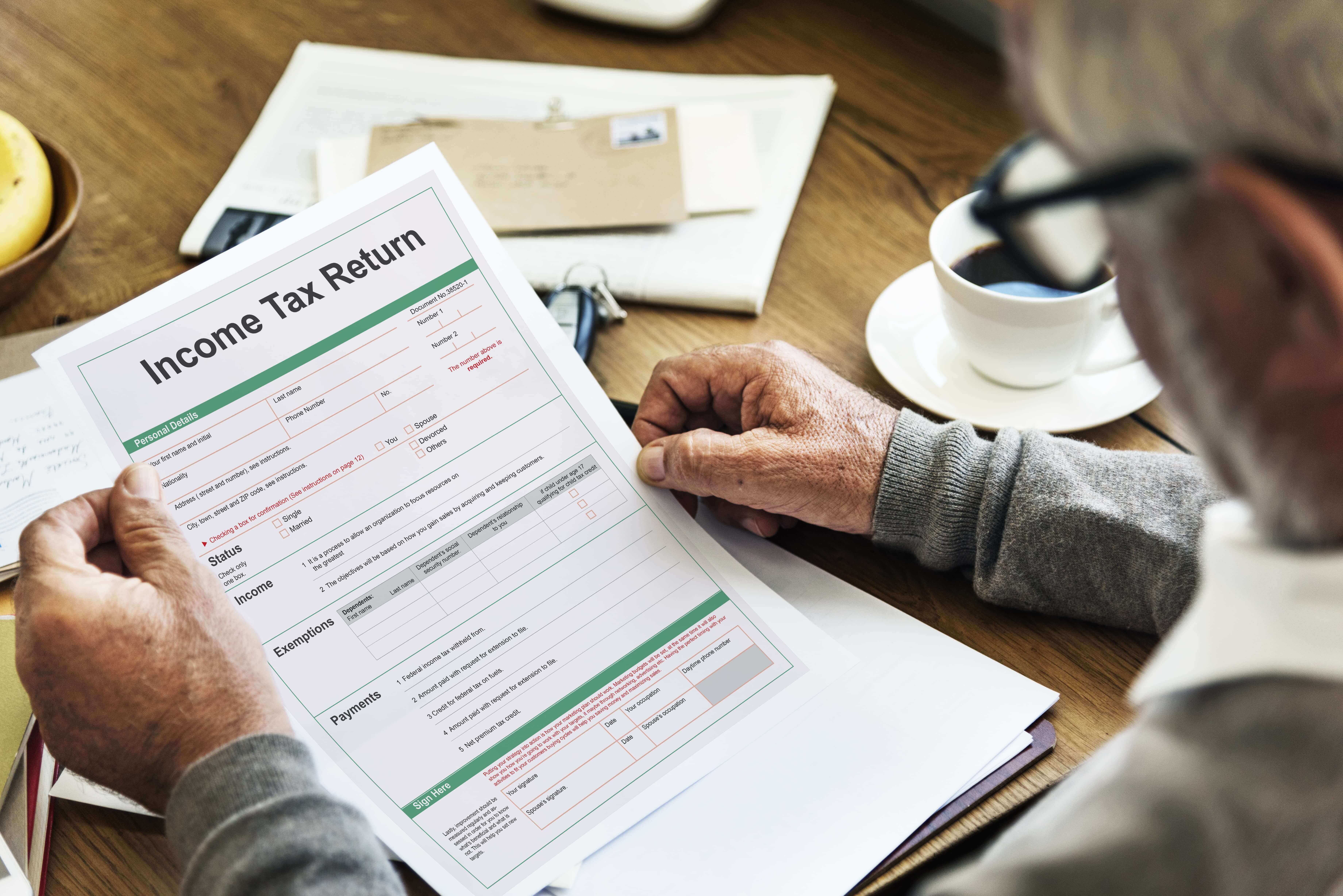 A man looking over his tax return which his accountant opted to extend the deadline of