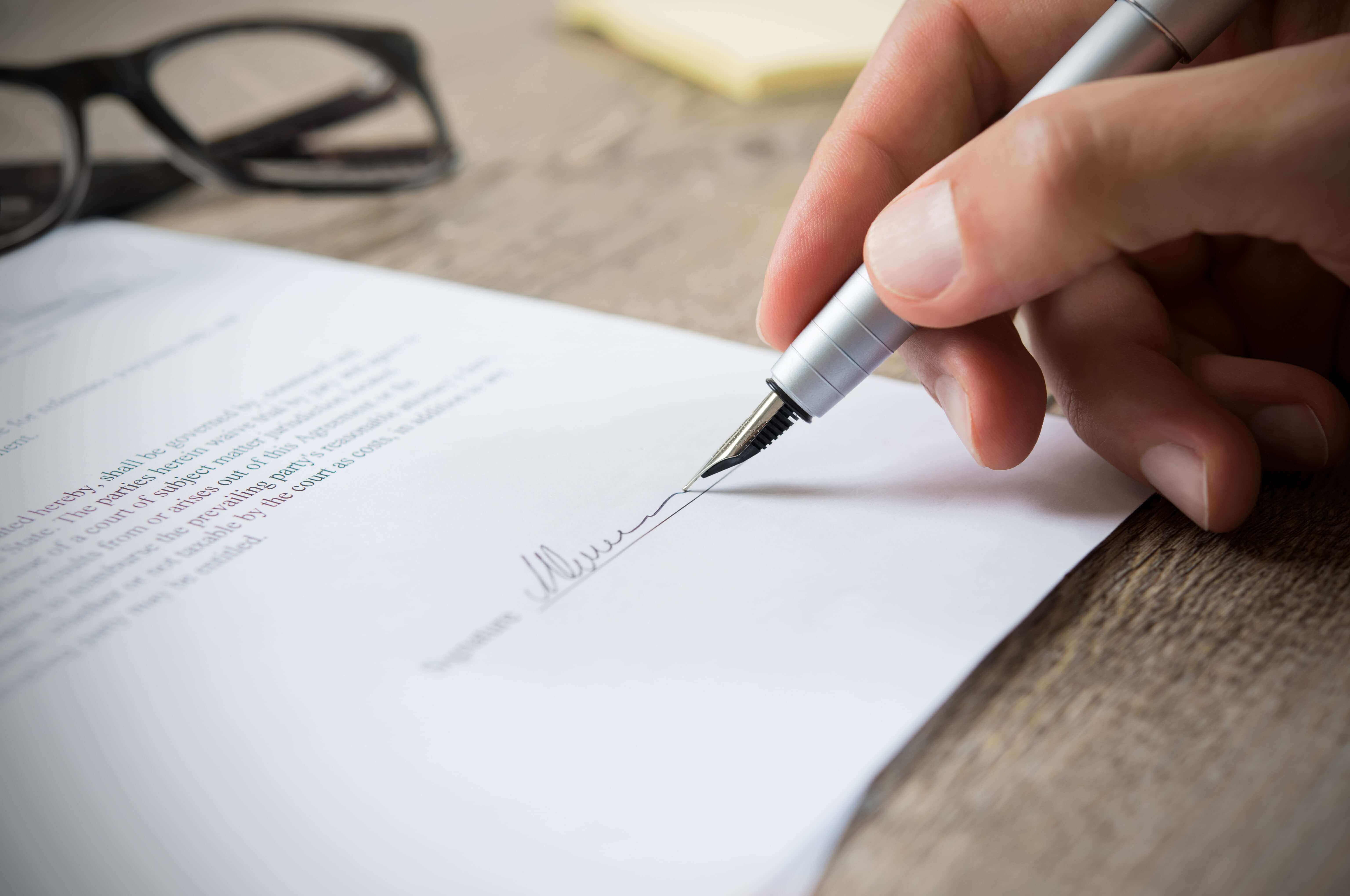 Man signing a financial reporting engagement with his Knoxville CPA