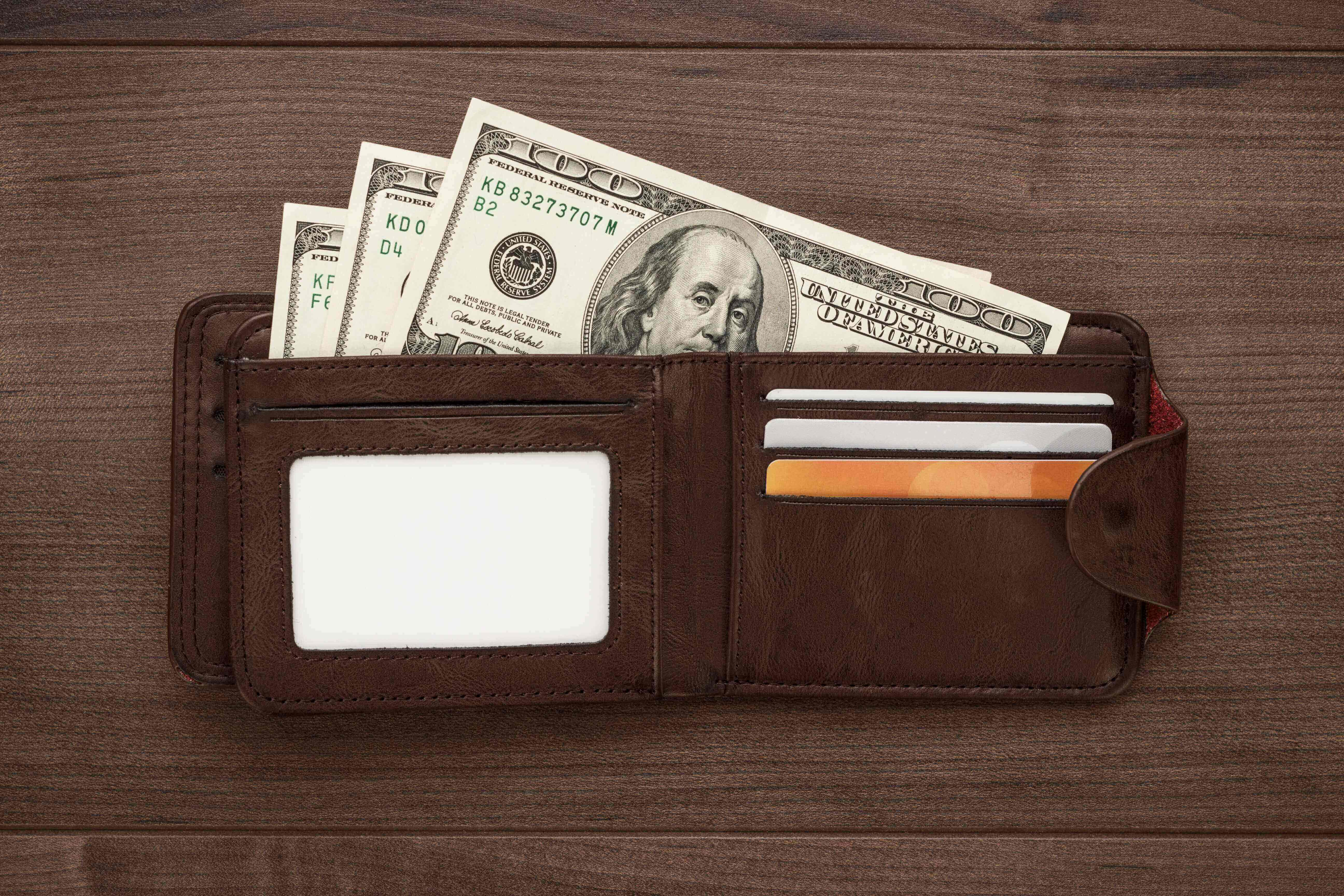 A wallet with money coming out of it.